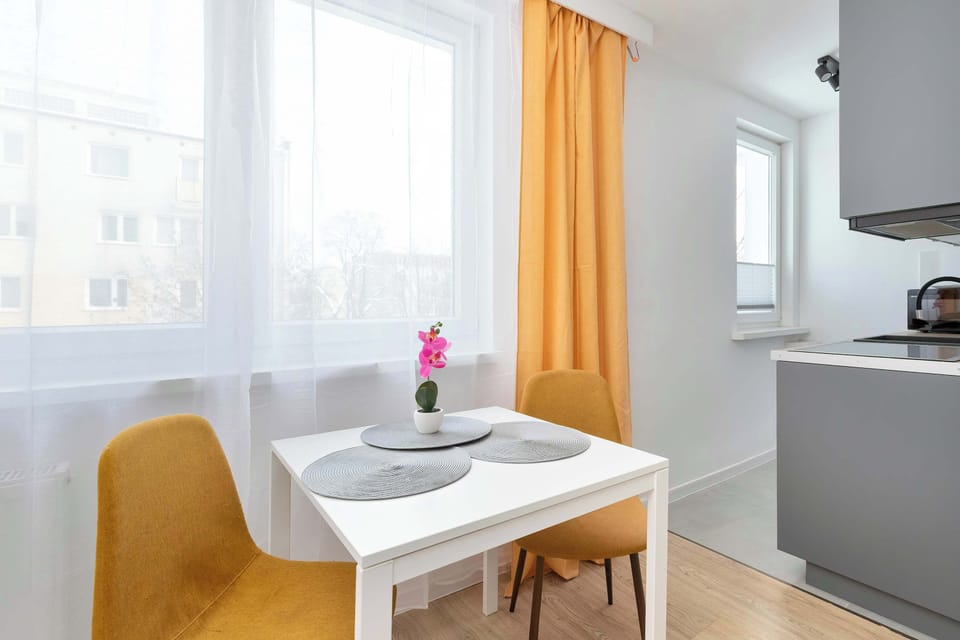 Cozy dining corner with small table, upholstered chairs, and window providing plenty of light.