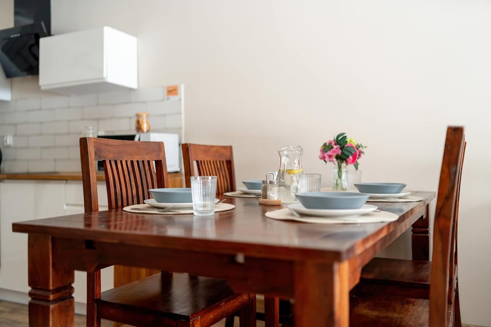 Refined dining space with a wooden table, elegant chairs, and abundant daylight.