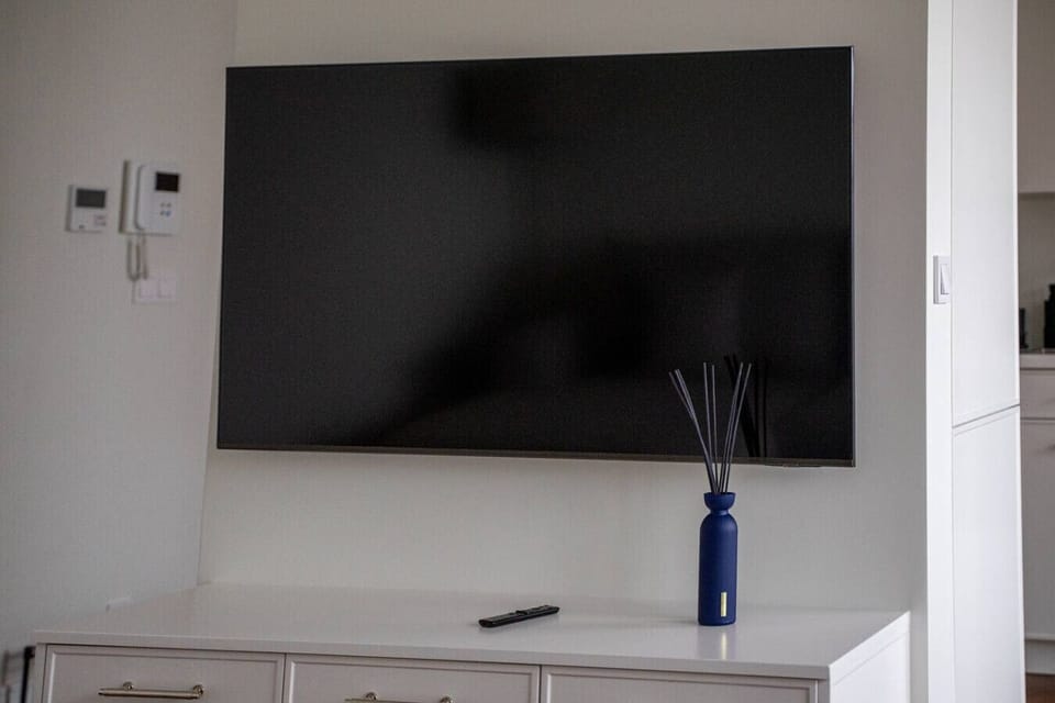 Living Area Details – Large Flat-Screen TV & Minimalist Entertainment Setup for Relaxing Evenings | Book Now with RENTUJEMY.COM