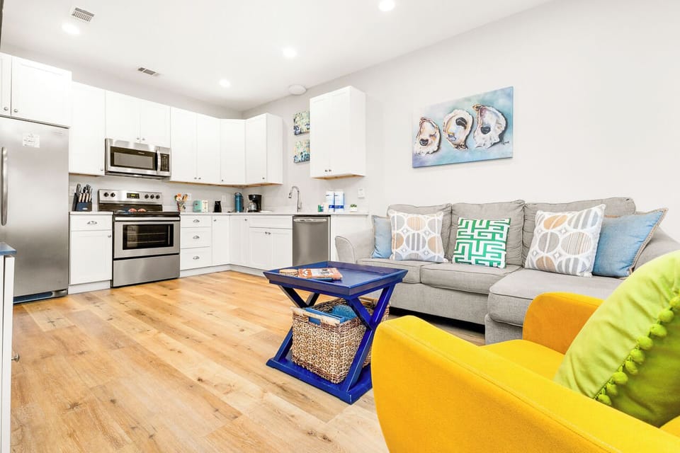 Unwind in your bright open-concept space where colorful seating meets a sleek kitchen, creating the perfect setting for memorable evenings.