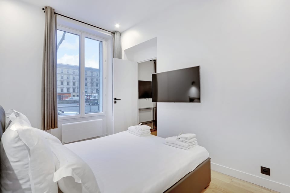 Première chambre avec un lit queen size et TV