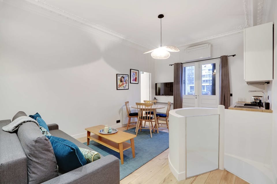 Salon confortable avec un canapé, TV et table à manger