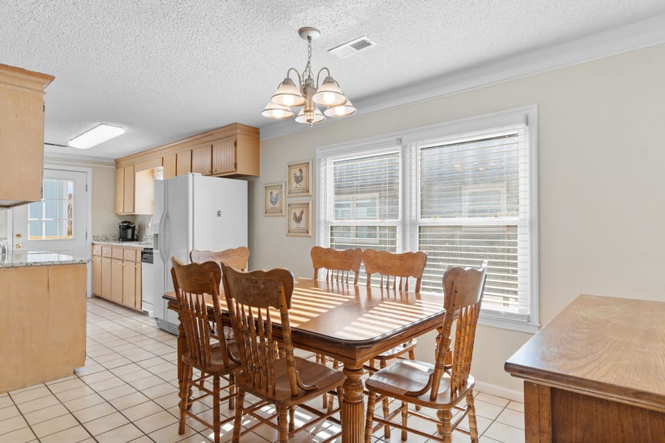 Gather around this welcoming dining table where your family meals become cherished memories, bathed in natural light from expansive windows.