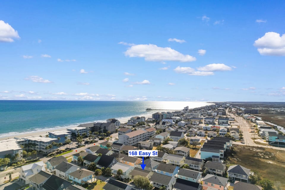 Aerial view of coastal community with beautiful ocean access and nearby amenities for a perfect beach getaway.