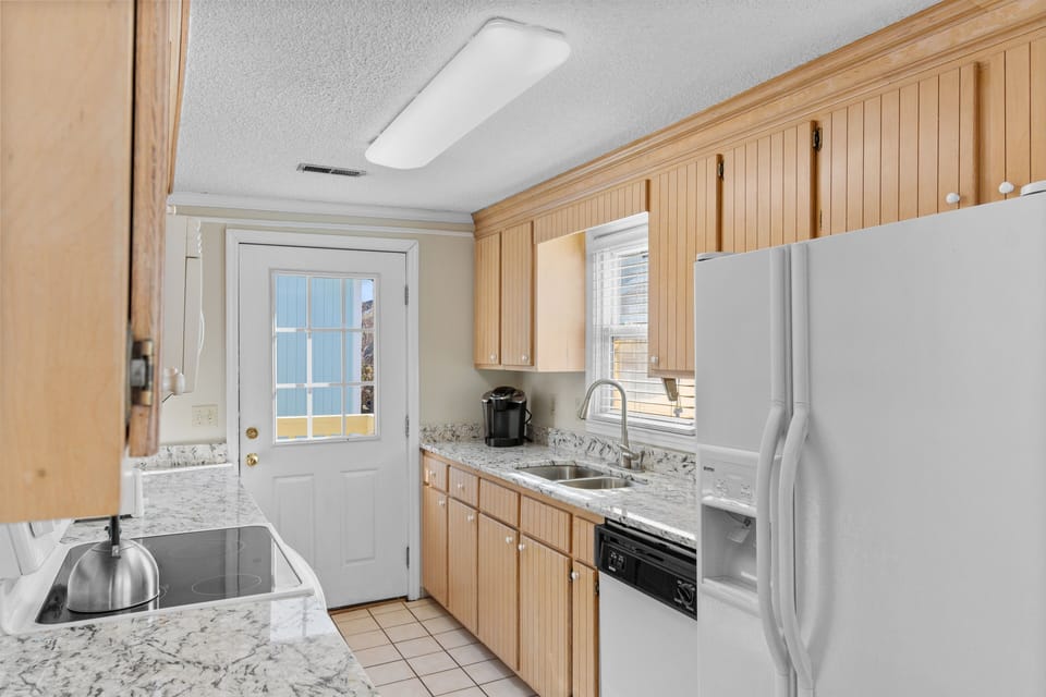 Your fully equipped kitchen awaits with granite counters, modern appliances, and natural light streaming through windows for memorable meal prep.