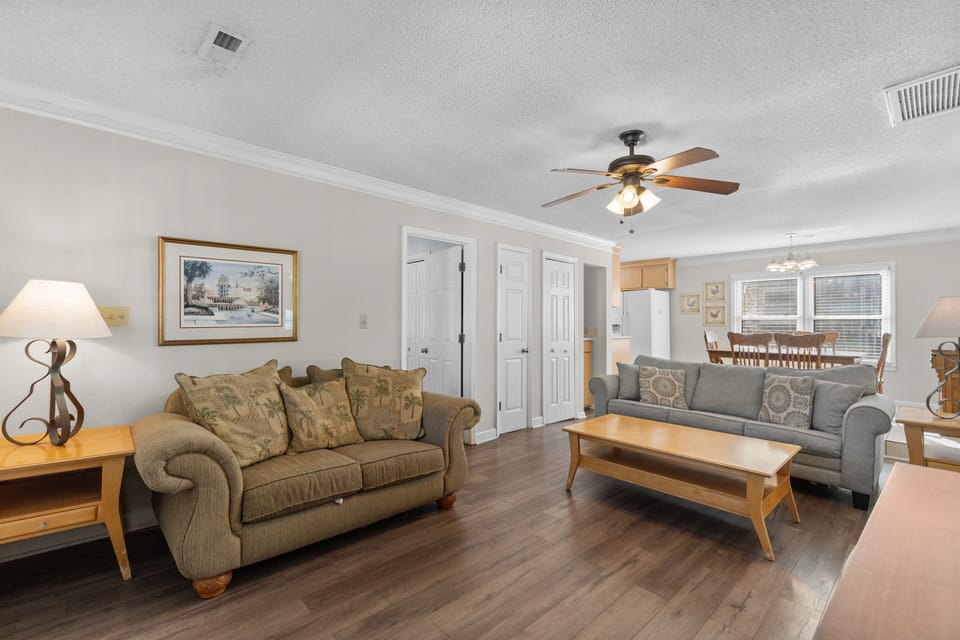 Sink into comfortable sofas in your spacious living room, where warm wood floors and gentle lighting create the perfect setting for relaxation.