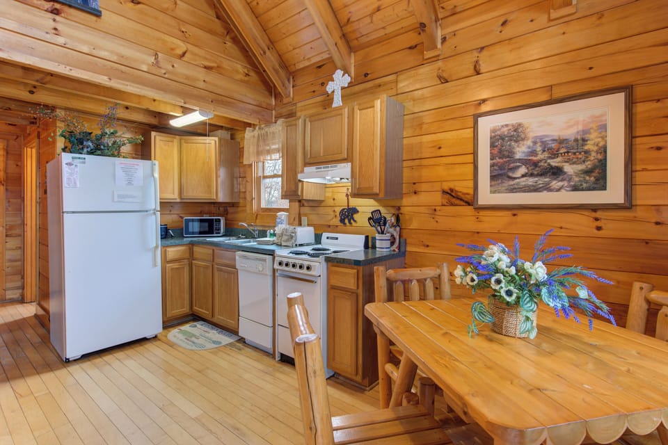 Your rustic log cabin kitchen and dining area await, where wood-beamed ceilings and warm timber walls create the perfect mountain retreat atmosphere.