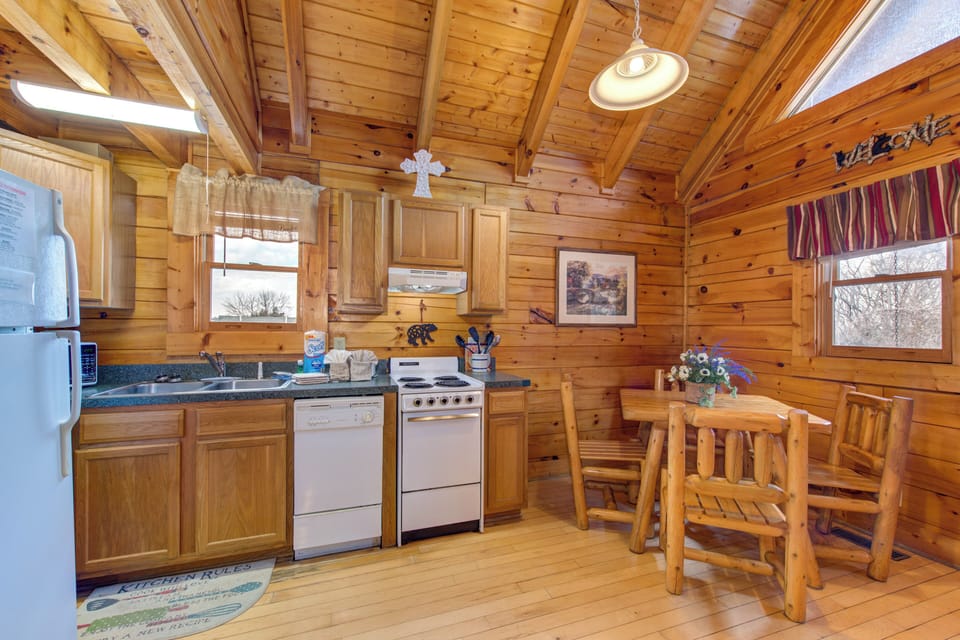 You'll love preparing meals in this cozy log cabin kitchen, where rustic wood beams create a warm atmosphere for cooking together.