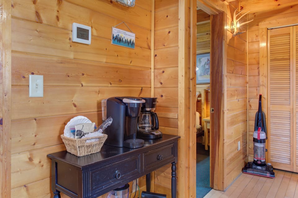 Warm wood surrounds your coffee station, perfect for brewing your morning cup in this cozy cabin retreat.