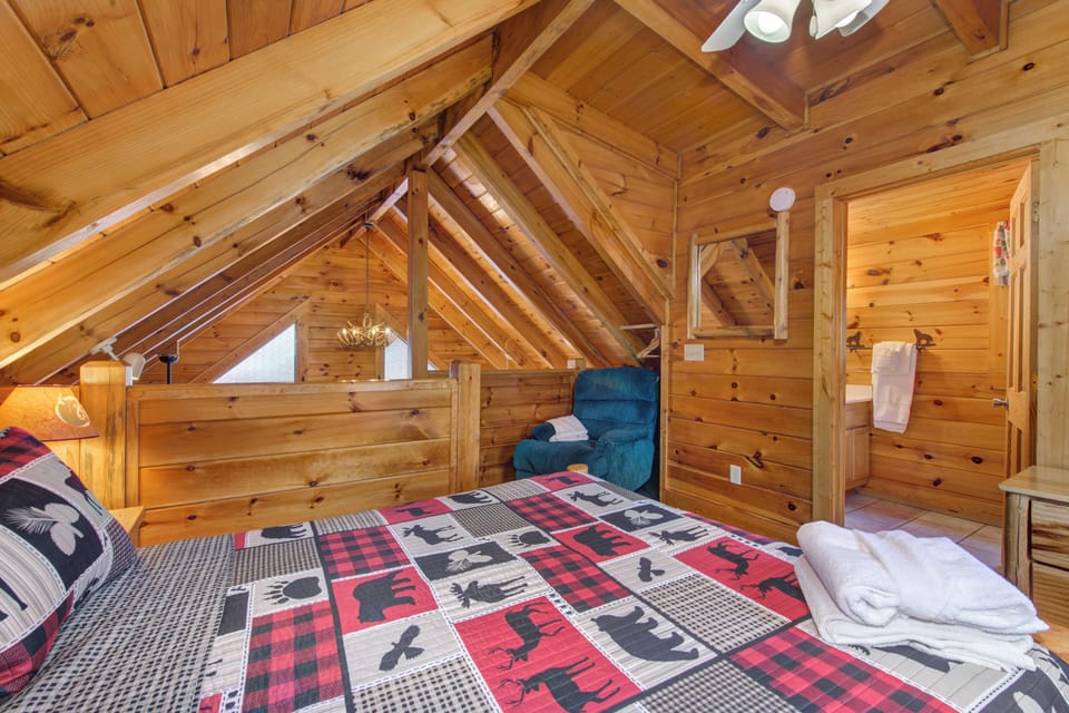 Cozy up in your rustic loft bedroom, where exposed wooden beams create intimate alpine charm and plaid linens invite peaceful mountain dreams.