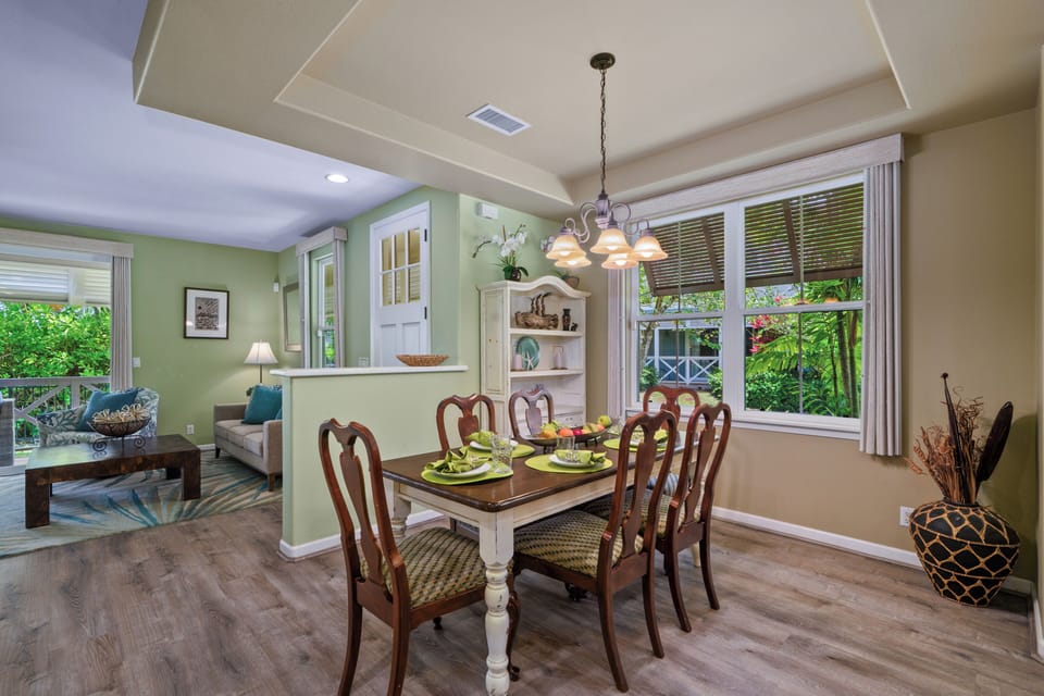 Gather around your elegant dining table overlooking lush tropical gardens, where memorable meals await in this bright, airy space.