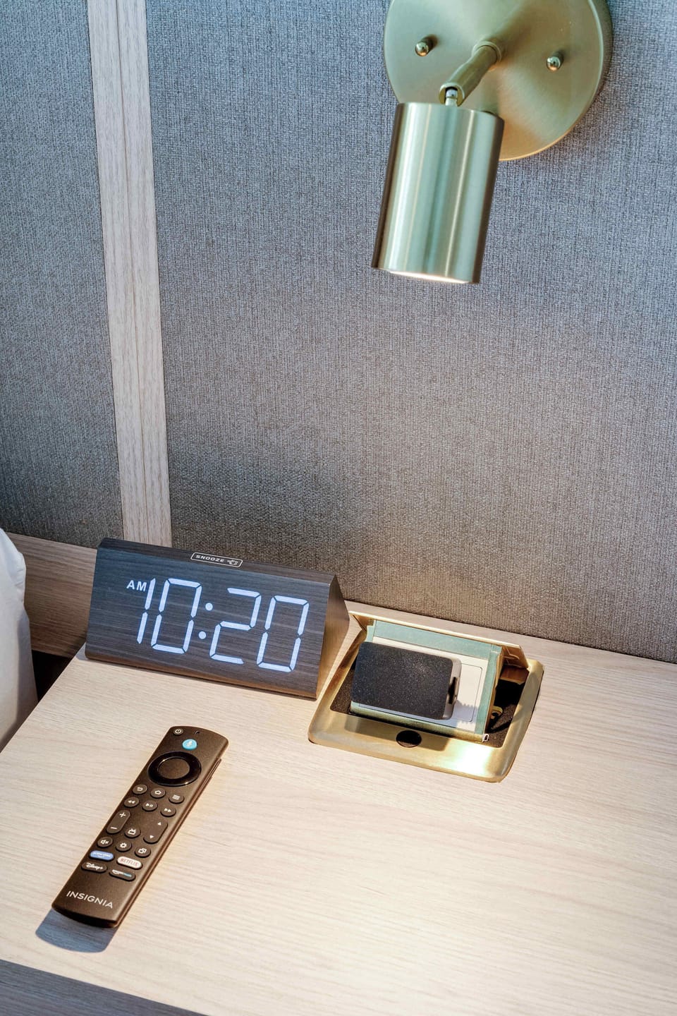 Everything you need within reach: bedside nightstand featuring a digital clock and TV remote