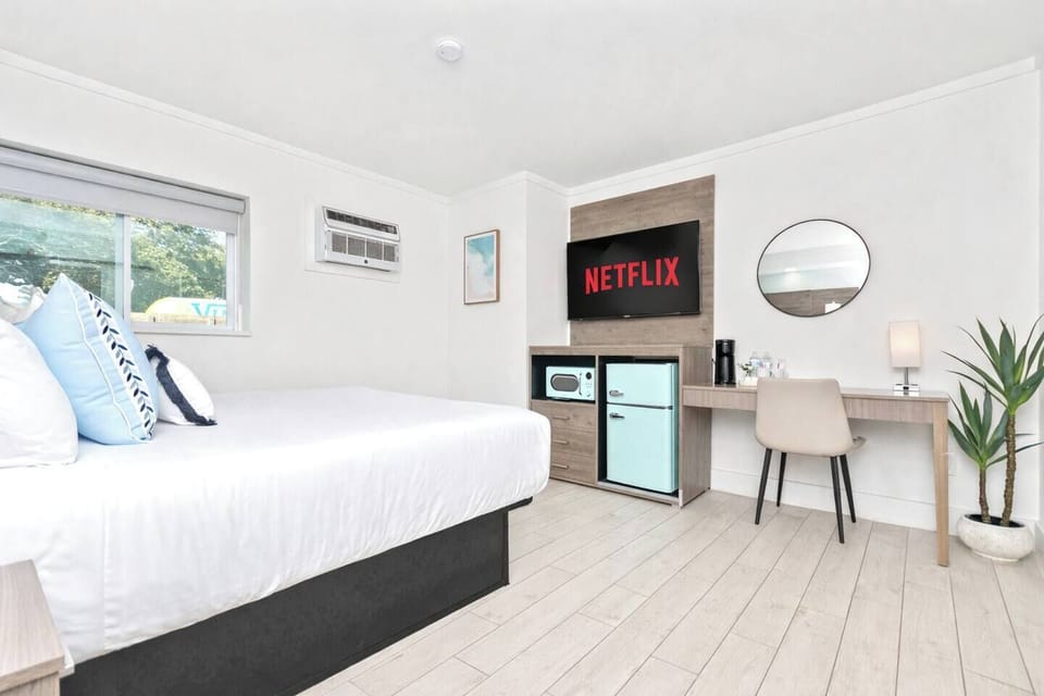 Comfortable queen bed with crisp linens, air conditioning, heating, TV, clothing storage, and room-darkening shades. Extra pillows and blankets provided for a restful stay.