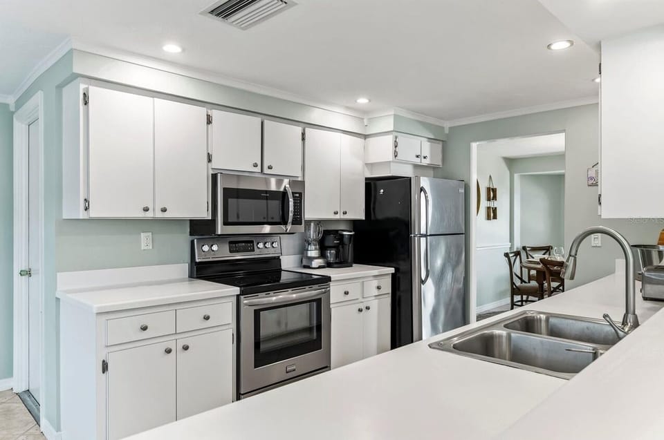 Your fully equipped kitchen features stainless steel appliances and pristine white countertops, perfect for preparing memorable meals during your stay.