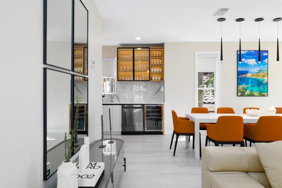 H2O Living offers a Large, Open Living Area on the 2nd Floor with a Leather Sectional, 65" Smart TV, Electric Fireplace, Dining Space, Remodeled Kitchen, and Patio with partial Gulf Views