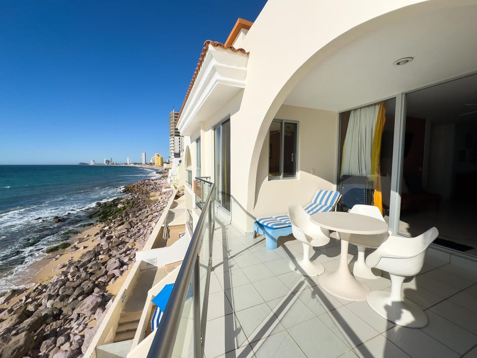 Oceanfront balcony with stunning coastal views and cozy seating
