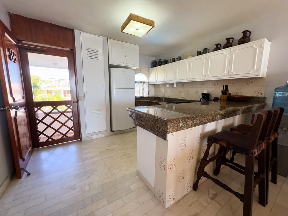 Bright kitchen with breakfast bar and garden views