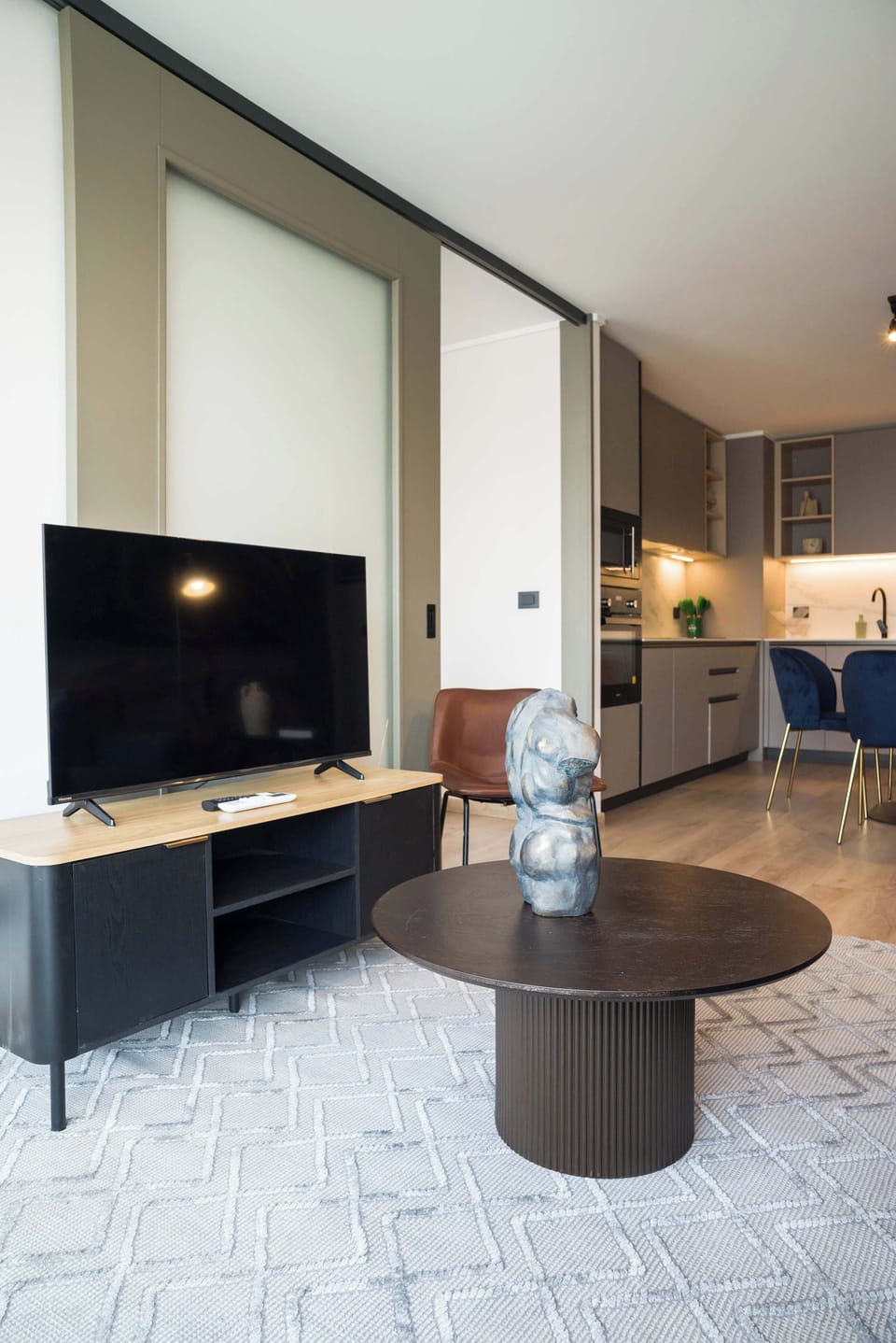 Stylish living area with modern decor and open kitchen, perfect for relaxation and entertainment.