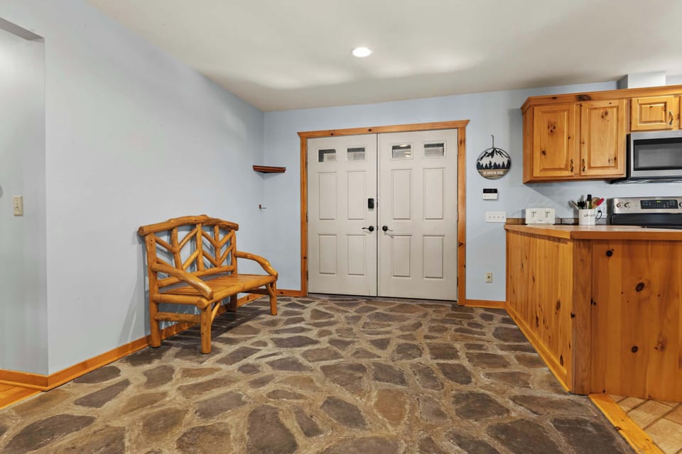 Entryway featuring elegant textured stone flooring that provides a welcoming and durable transition into the home.