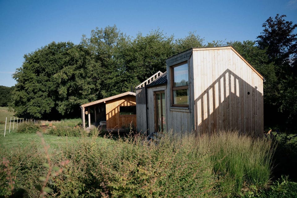 A Cosy Cabin nestled in nature, with the Foyer in the background, a welcoming space to gather and share