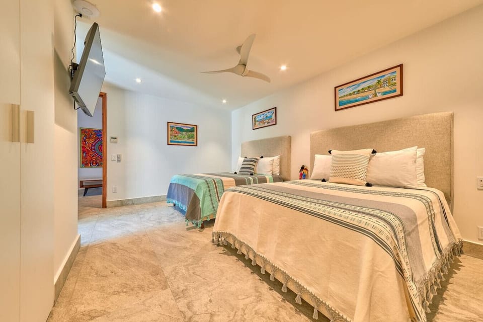 Bright and cozy bedroom with two comfortable queen beds, soft linens, and warm décor.