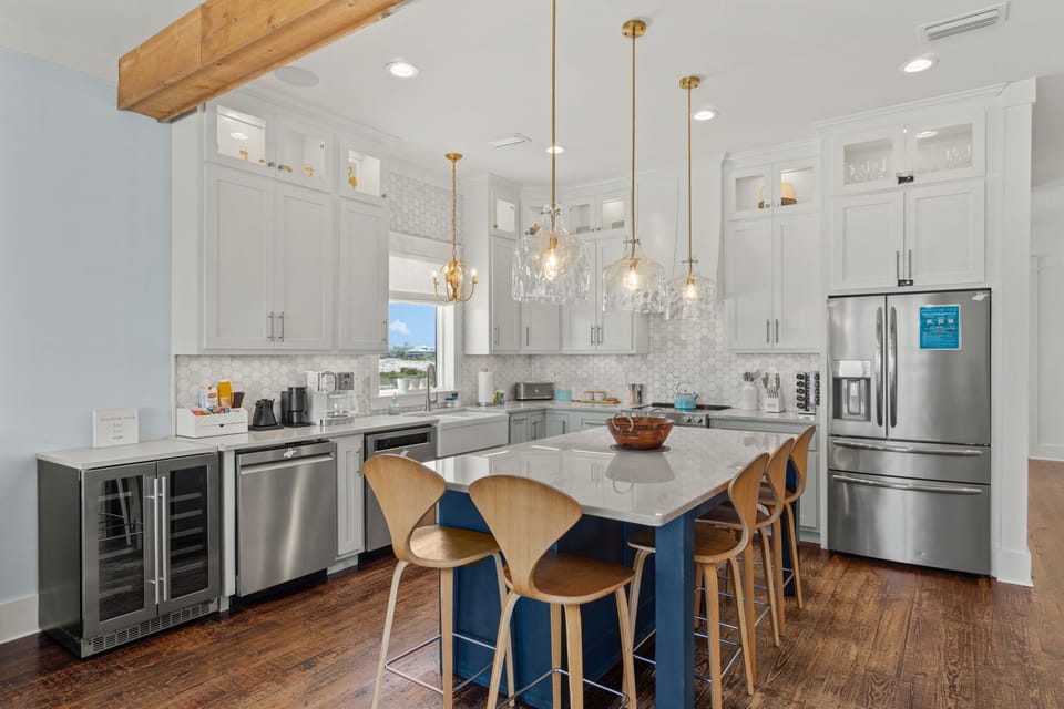 A chef's kitchen built for crowds: quartz island, beverage fridge, dual dishwashers, room to roam