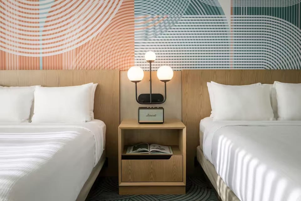 Drift off in crisp double beds under warm bedside lighting.