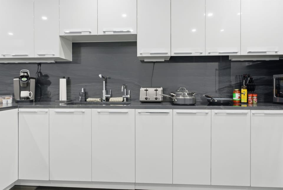 Fully equipped kitchen featuring a Keurig coffee station, filtered water faucet, and extensive cabinetry. We provide coffee, tea, and professional cookware for the Wolf induction cooktop, ensuring a seamless culinary experience in Bar Harbor.