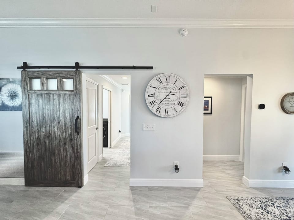 Barn Door w/ Option to Close Off Guest Quarters w/ 2x Guest Rooms, Guest Bath, Laundry Room & Garage Access. To the Right is the Primary Suite