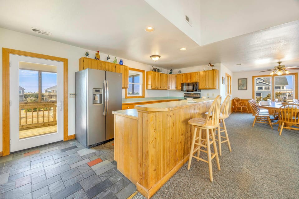 Step into your spacious kitchen where warm wood cabinetry and modern appliances await your culinary adventures.
