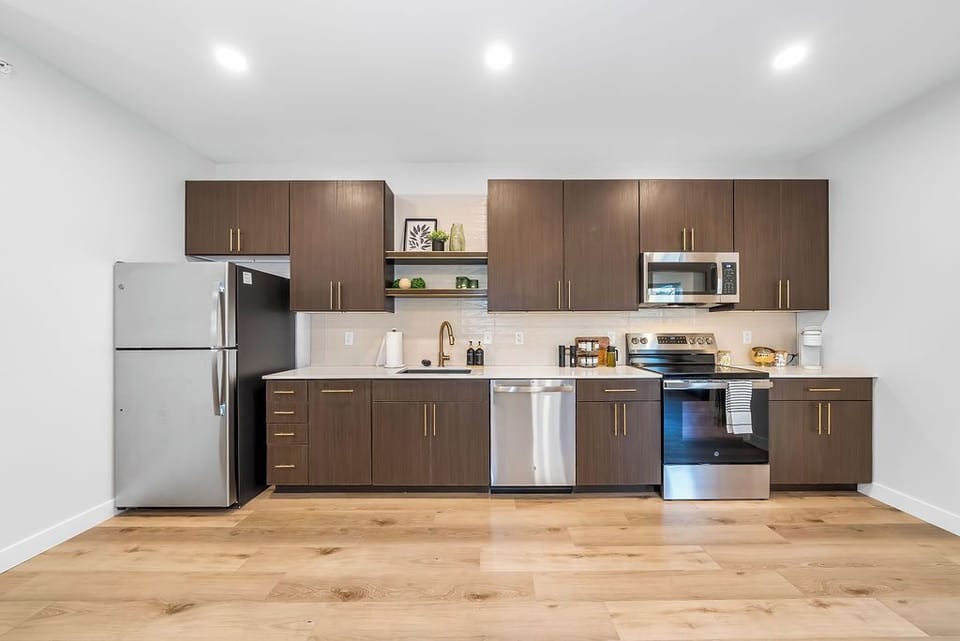 Your sleek modern kitchen awaits with stainless steel appliances and warm wood cabinets, perfect for creating memorable meals during your stay.