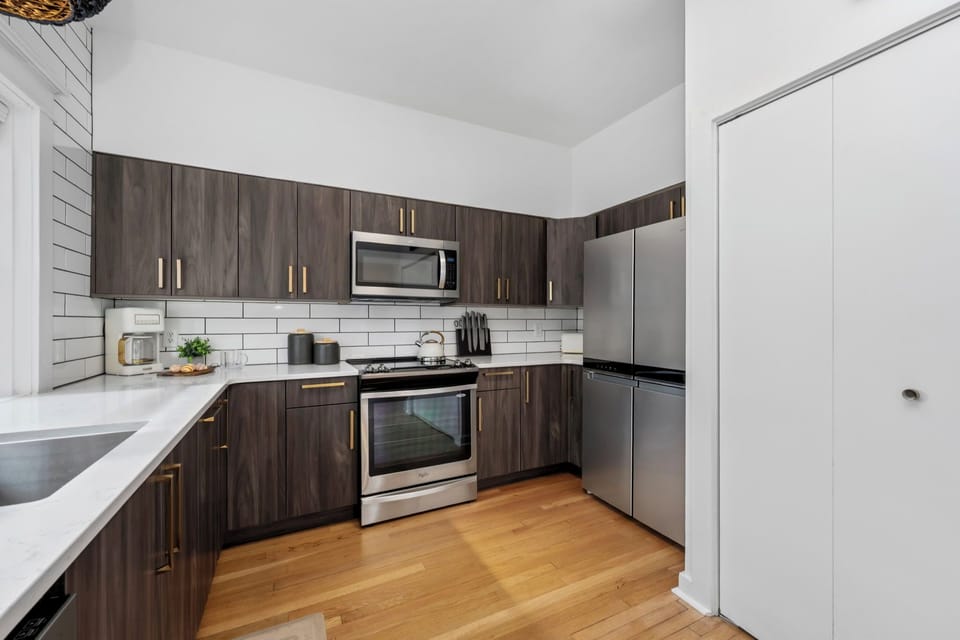 Your modern kitchen features sleek wood cabinets, stainless steel appliances, and bright subway tile backsplash—perfect for preparing memorable meals during your stay.