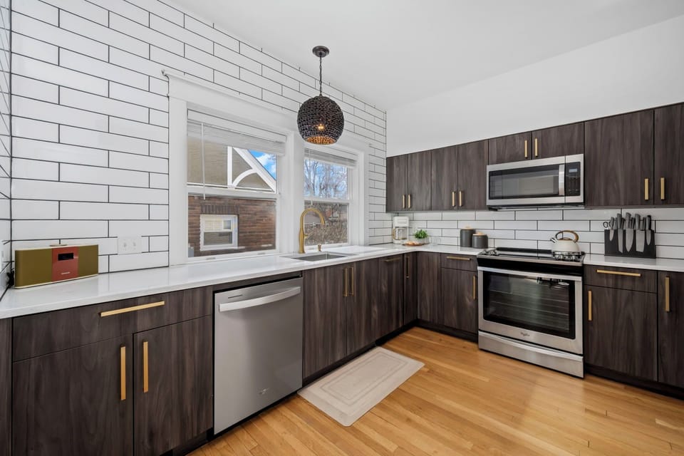 Cook in style with sleek dark cabinetry, quartz counters, and stainless appliances in your fully-equipped modern kitchen.