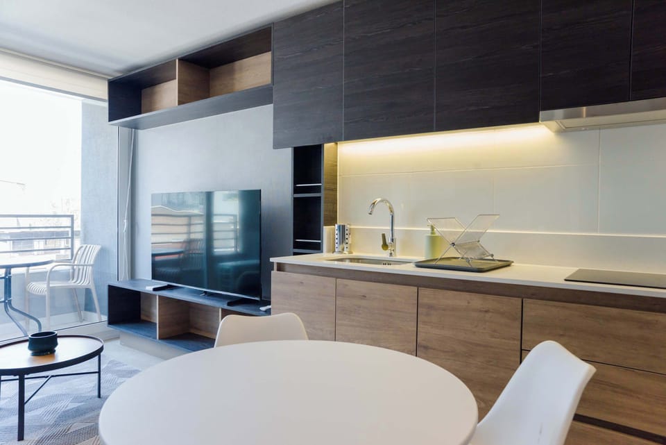 Stylish kitchen and living area with a spacious balcony view, perfect for relaxing and entertaining.