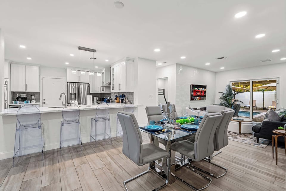 Open plan kitchen and dining, with the pool beyond.
