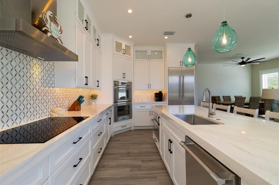 Step into your dream kitchen with gleaming white cabinets, stunning backsplash, and spacious quartz island perfect for cooking memorable meals together.