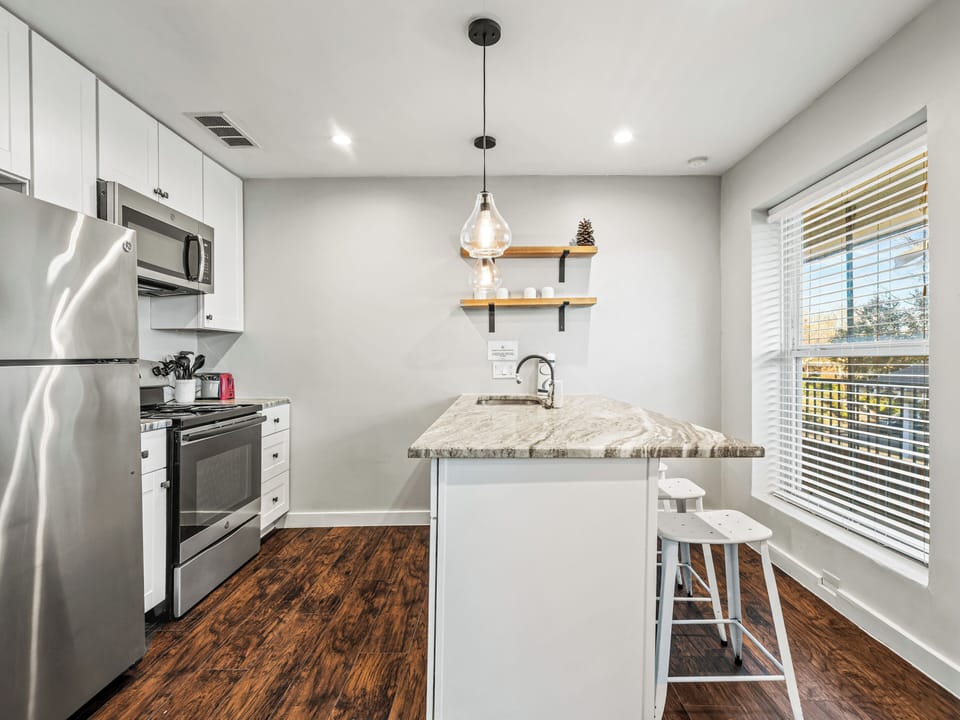 Your fully equipped kitchen features modern appliances and a marble breakfast bar where you can enjoy morning coffee.