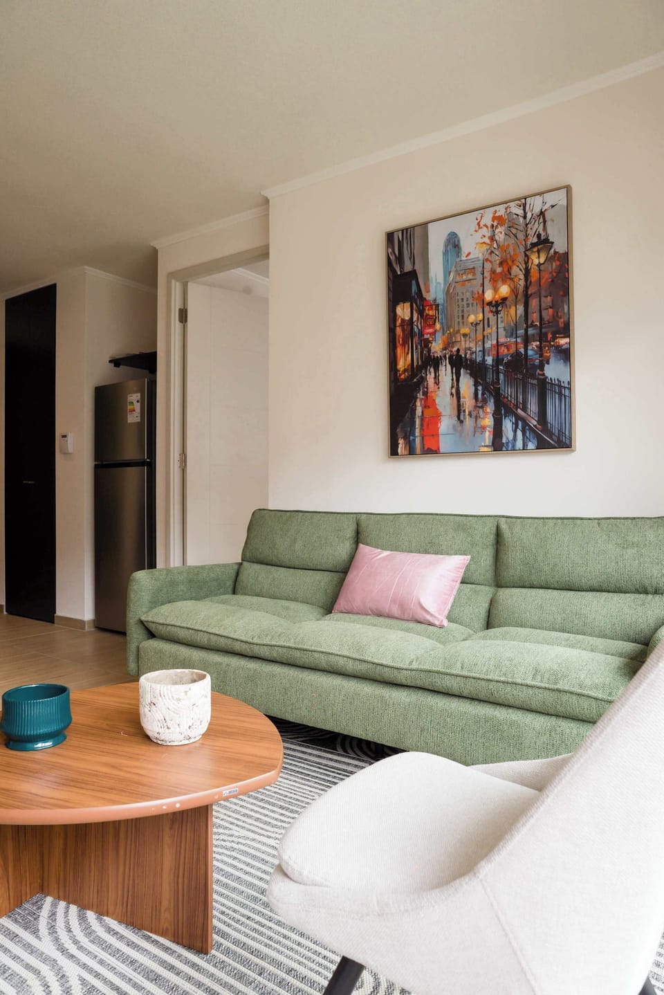 Relax in this stylish living room with a comfy green sofa and vibrant artwork, perfect for unwinding after a day exploring the city.