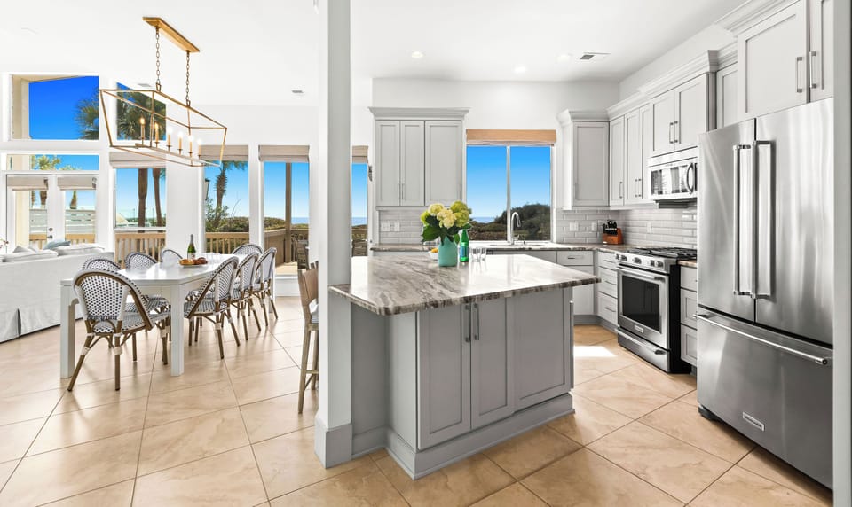 Your dream kitchen awaits with polished counters, stainless appliances, and stunning ocean views through every window.