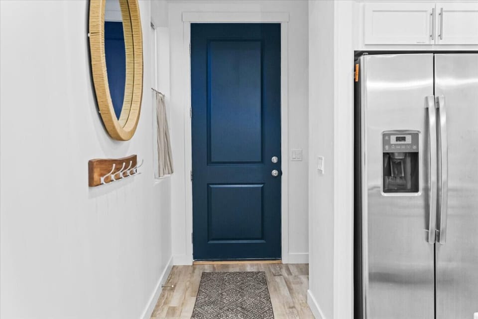 Bright, welcoming entryway with modern touches, warm accents, and a bold, stylish blue door