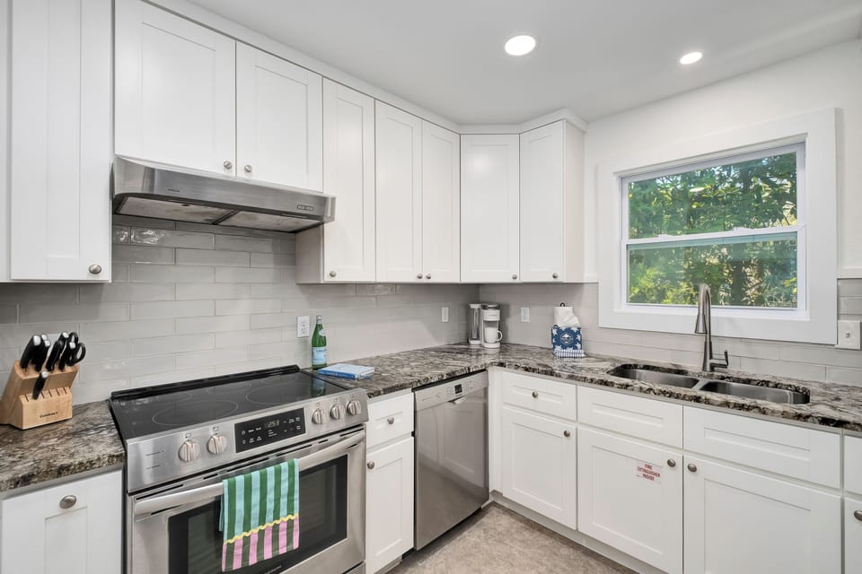 Your bright, fully equipped kitchen features granite countertops, modern appliances, and cheerful garden views—perfect for preparing meals and morning coffee during your stay.