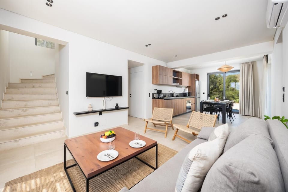 Open-plan living room with sofa, dining area, kitchen, A/C, WiFi internet, and satellite TV