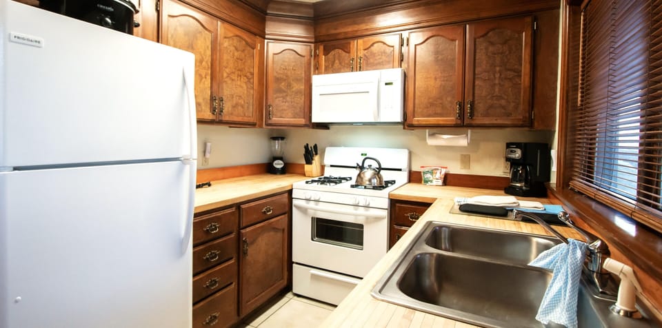 A fully equipped kitchen with rich wooden cabinets and modern appliances, perfect for preparing meals.
