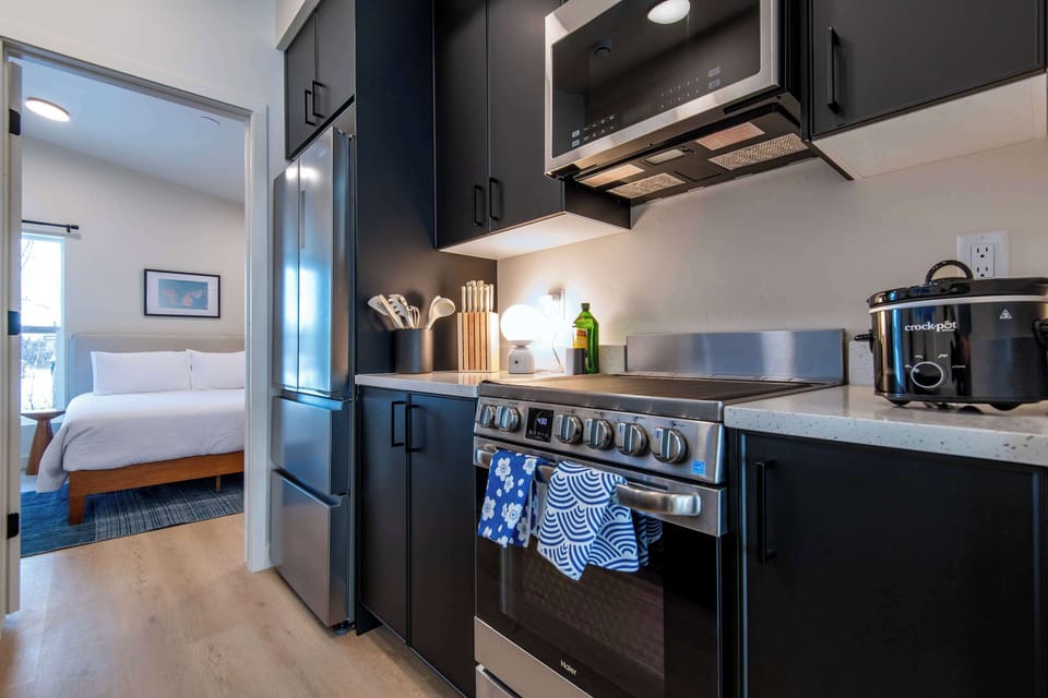 Fully equipped kitchen leading to the bedroom.