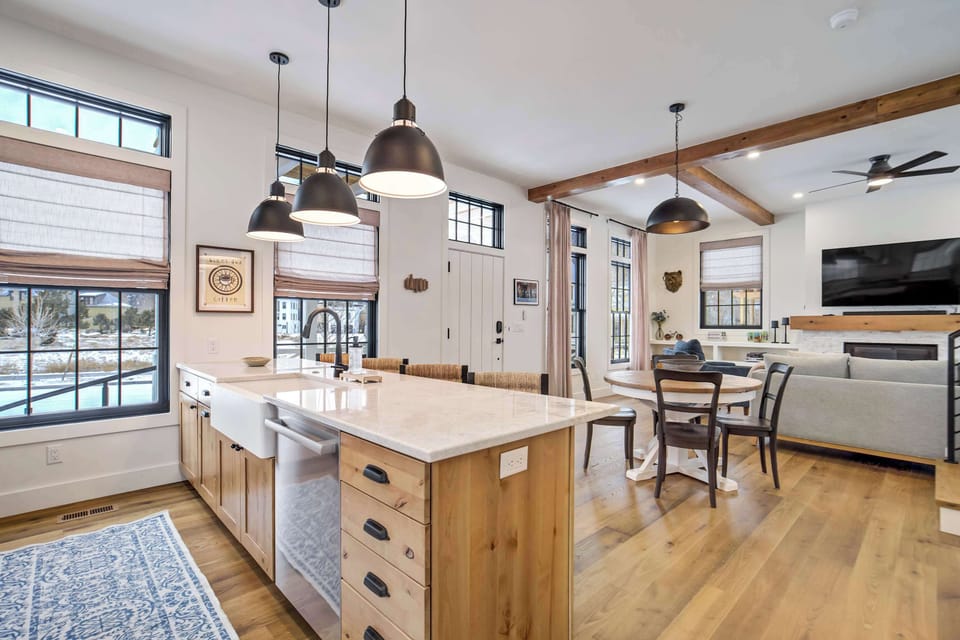 The fully stocked kitchen features a large island with an integrated farmhouse sink and dishwasher. This open workspace keeps you connected to the dining and living areas while preparing meals or snacks for the group.