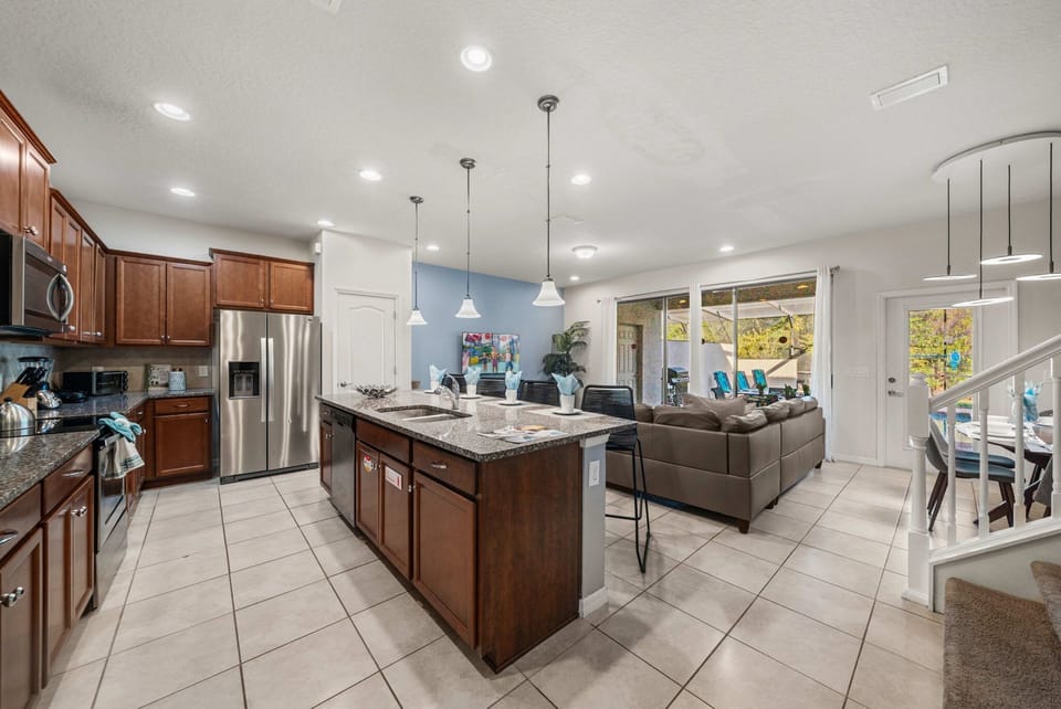 Open-concept living with a modern kitchen-granite island seating for 4, stainless appliances, and easy flow to the lounge and screened patio by the pool. Gather and unwind.