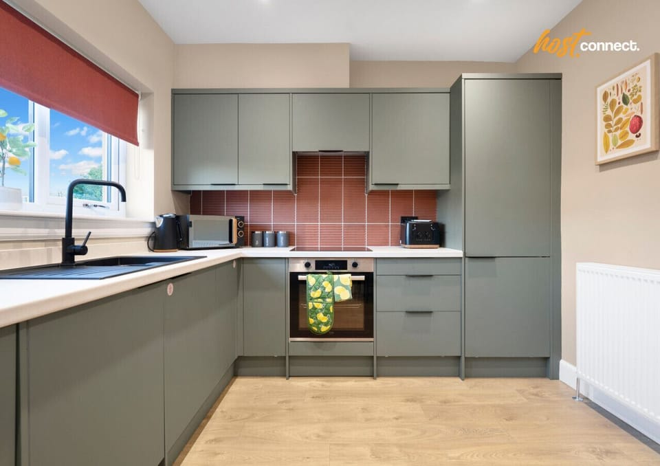Fully equipped kitchen with cabinetry, hob, oven, washer, microwave, kettle, toaster, and fridge-freezer.