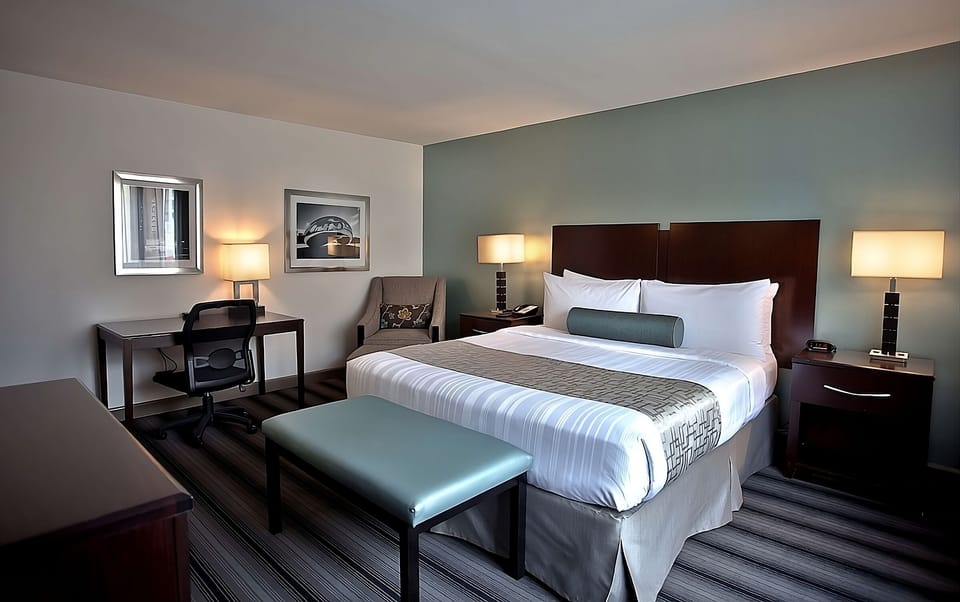 Unwind in a serene king bed with warm bedside glow.