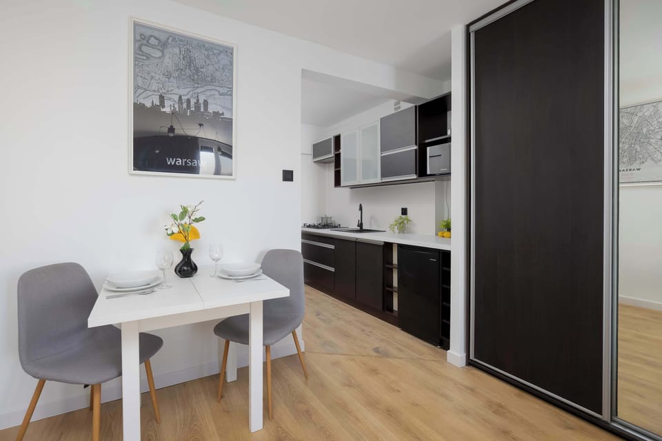 Compact kitchenette combined with a small dining table and clean, modern finishes.