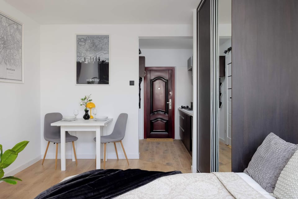 Spacious studio layout showing the sleeping area, storage units, and minimalist décor.